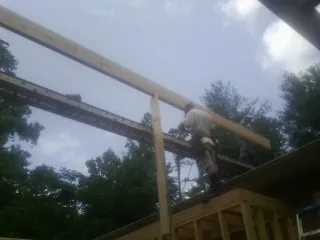 Carpenter setting a ridge beam over a new addition frame — Ice Dam Removal by Roofing Brothers in Taconic