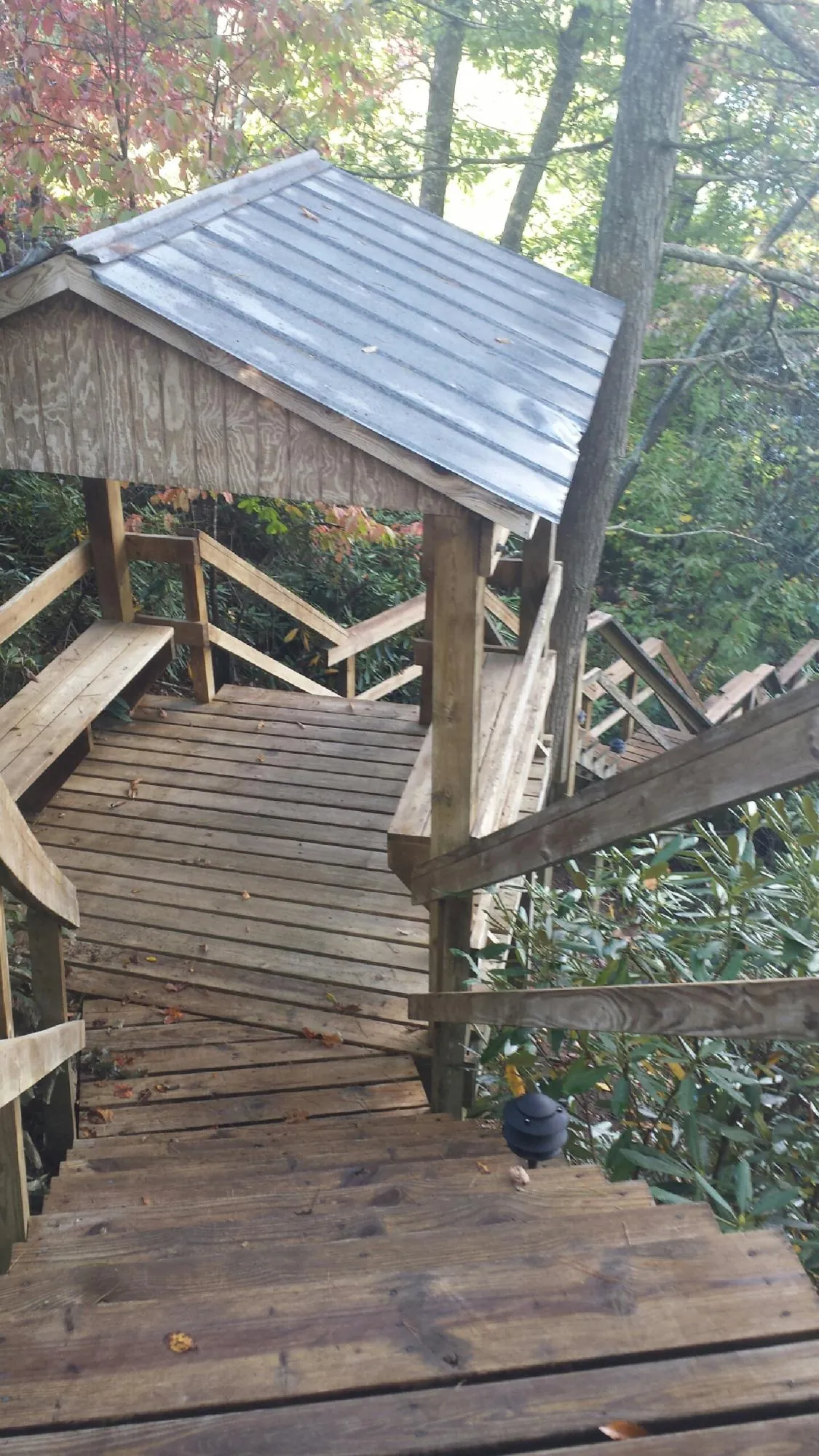 Metal roofed shelter over wooden steps on a wooded walkway — Skylight Repair & Installation work by our crew in Taconic